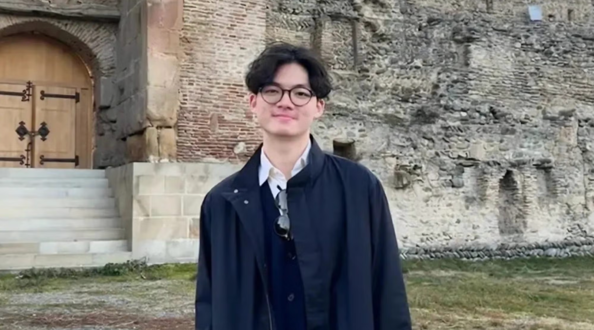 Georgetown senior, Brian Cody Wibowo, stands in front of stone building